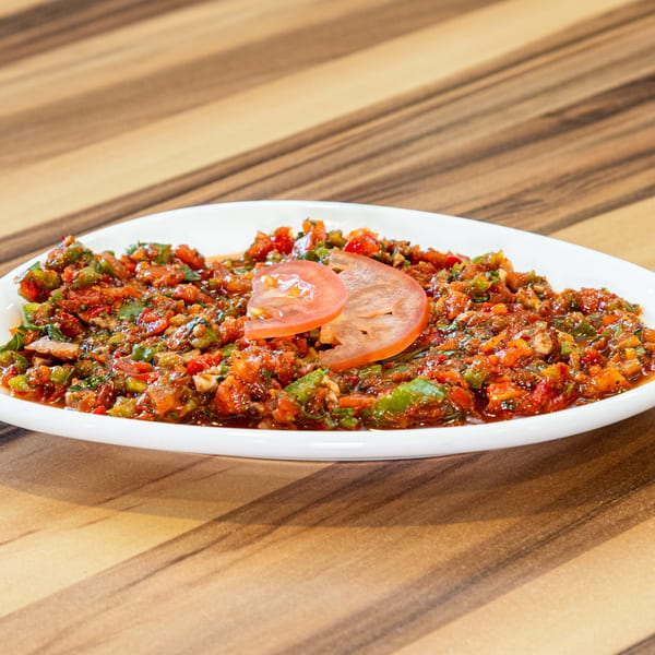 Turkish Ezme salad, a vibrant mix of finely chopped tomatoes, peppers, and herbs, garnished with tomato slices.
